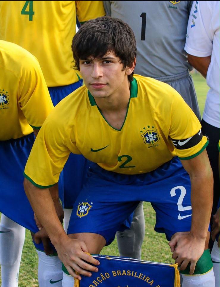 Lucas Farias com a camisa da Seleção Brasileira Sub-15, segurando a flâmula do jogo Brasil x Bolívia